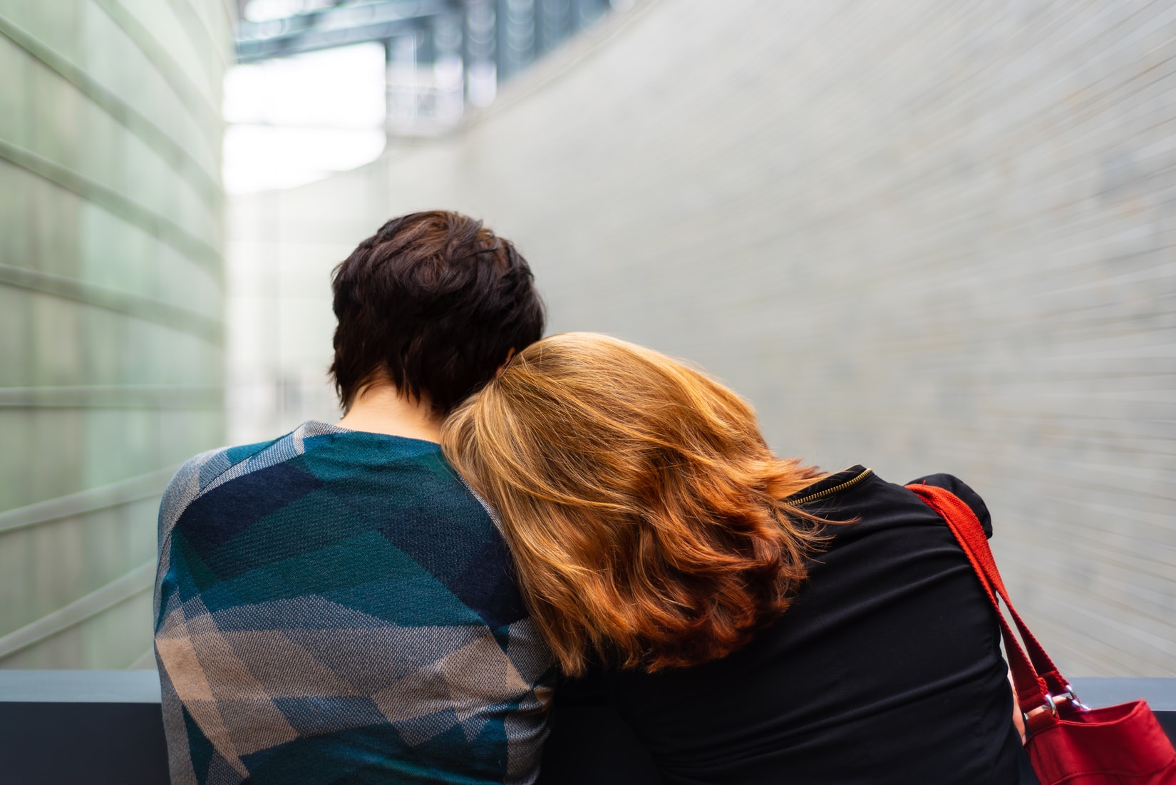 mother resting head on sons shoulder