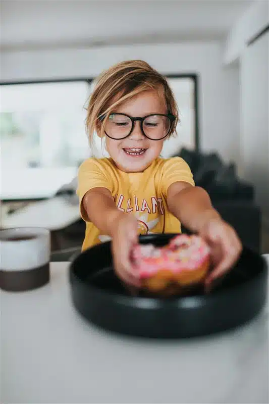 a child holding a donut